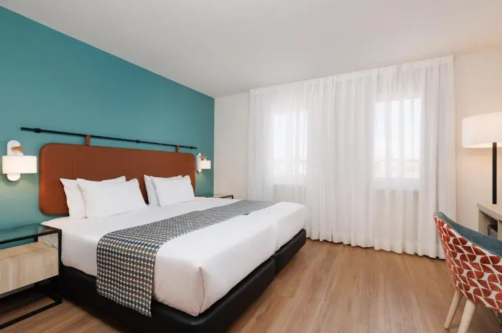 Contemporary double room with turquoise feature wall at Exe Vienna Hotel